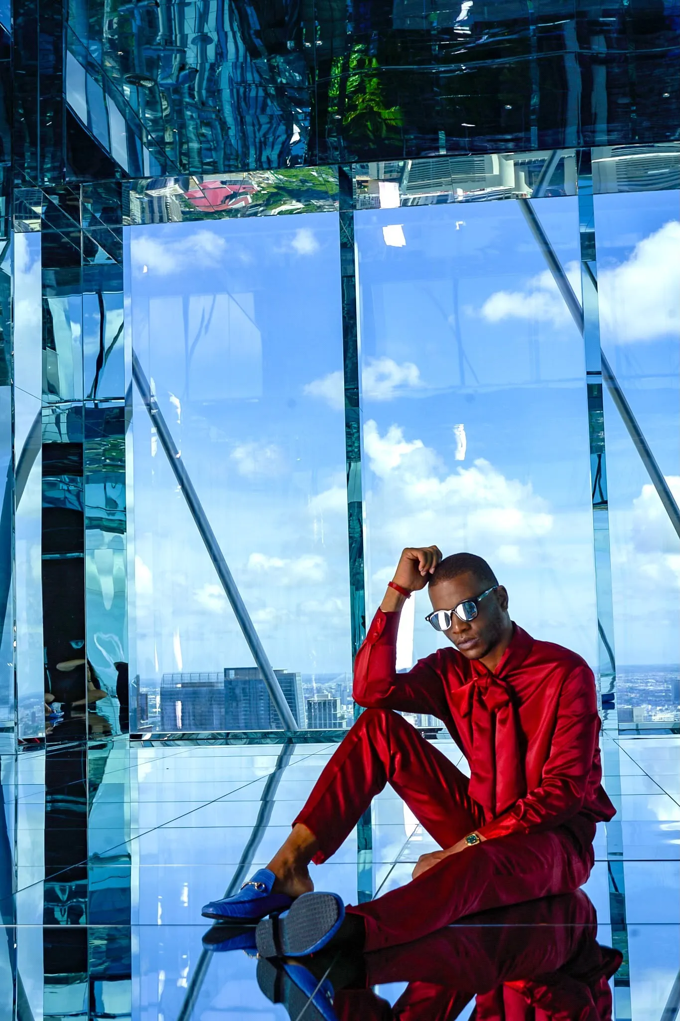 Red suit, seated against the glass