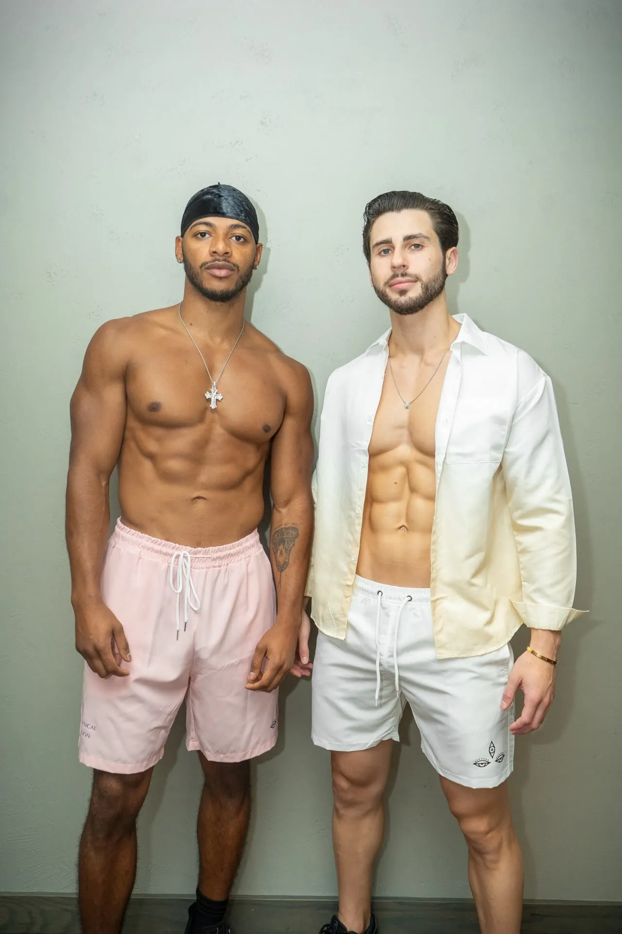 Two men in NONPAREIL swim trunks, pink and white