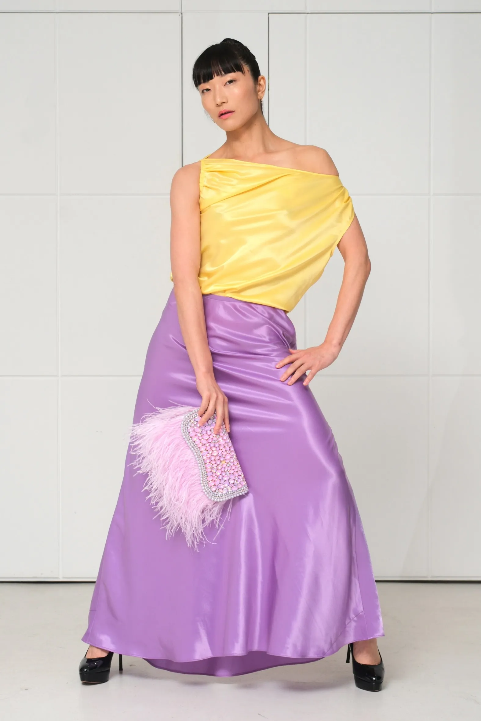 Yellow silk top, lilac skirt, feathered clutch