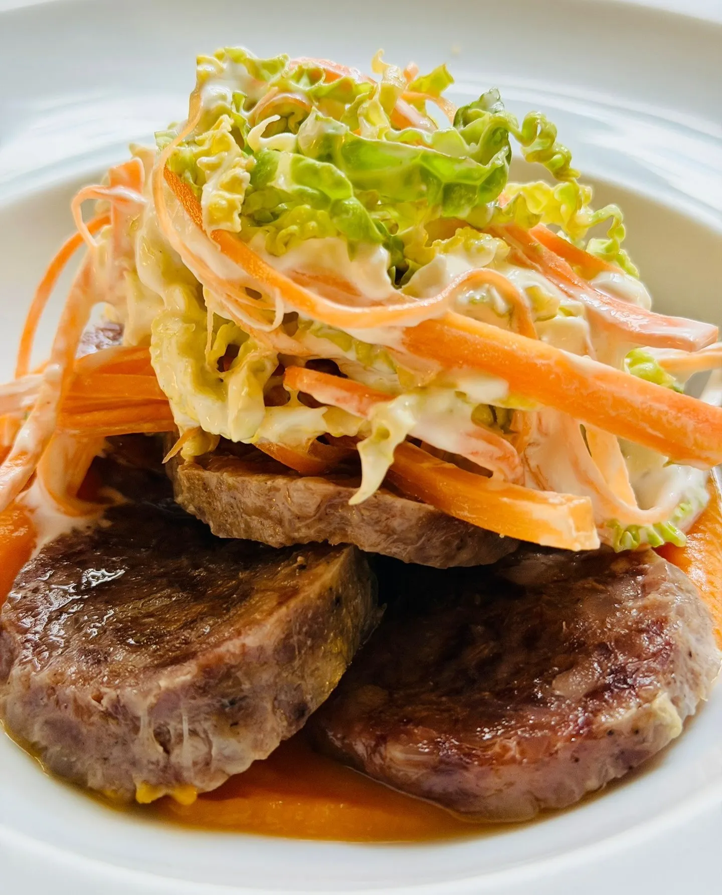 Beef with shaved vegetables on a white plate