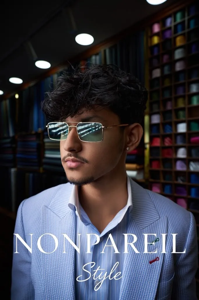 Sunglasses campaign, blue suit against fabric bolts
